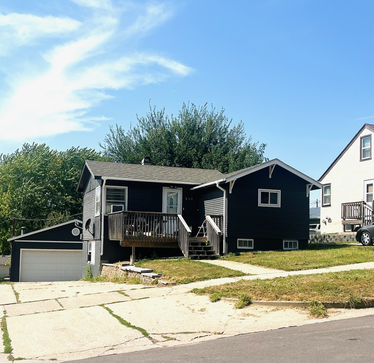 A two-story residential home with blue siding and white trim, featuring a front porch and an attached single-car garage, located at 1409 S Norton Ave, Sioux Falls, SD.